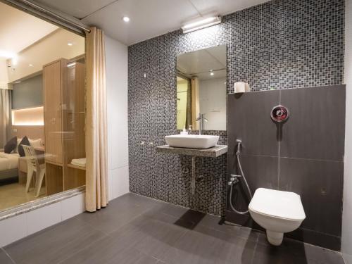 a bathroom with a sink and a toilet at Hotel Grand Seasons- Navi Mumbai in Navi Mumbai