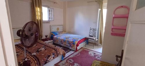 een slaapkamer met een ventilator en een bed erin bij Lovely 5Bedroom Villa -Compound - Swimming Pool at Green Oasis Resort in ‘Izbat as Sarāḩnah
