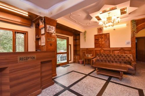 een wachtkamer met een bank en een tafel bij Hotel Avalanche in Shimla