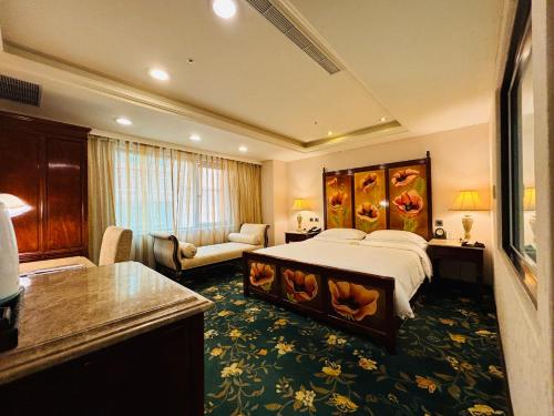 a hotel room with a bed and a living room at Royal Seasons Hotel Taipei ‧ Nanjing W. in Taipei
