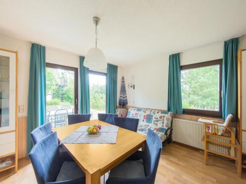 a dining room with a wooden table and blue chairs at Spacious Apartment in Frankenau Hesse near the Forest in Frankenau