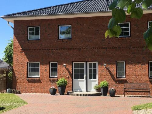 un edificio de ladrillo rojo con una puerta blanca y un banco en Charming Apartment in Oldenburg in Holstein with Terrace, en Oldenburg in Holstein