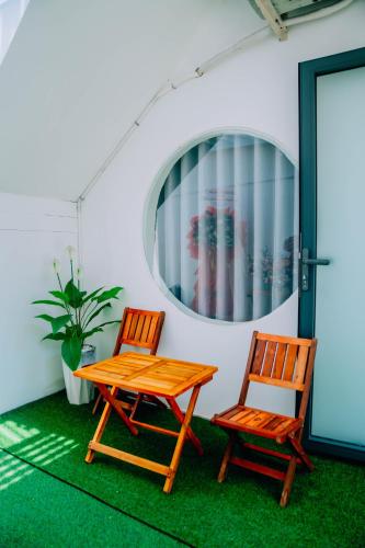 two wooden chairs sitting next to a wooden table at Thuyền Xưa Homestay Đảo Phú Quý in Cu Lao Thu