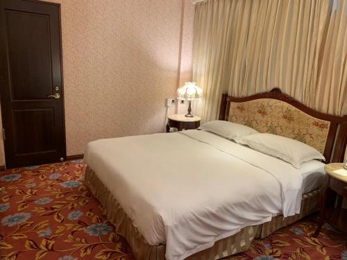 a bedroom with a large bed in a hotel room at Royal Seasons Hotel Taipei ‧ Nanjing W. in Taipei