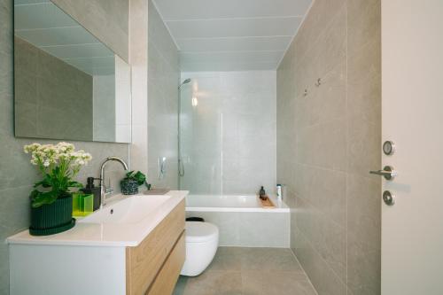a bathroom with a toilet and a sink and a tub at Lapin Luxury Hotels By Nimizz in Tel Aviv