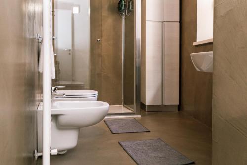 a bathroom with a toilet and a shower and mats at GOMES COMFORT HOUSE in Valeggio sul Mincio