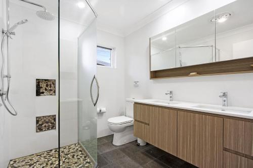 Un baño con inodoro, lavabo y ducha. en Bellevue, en Manyana