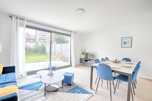 un salon avec une table et des chaises bleues dans l'établissement Maison Créteil - Maison climatisée avec jardin, à Créteil
