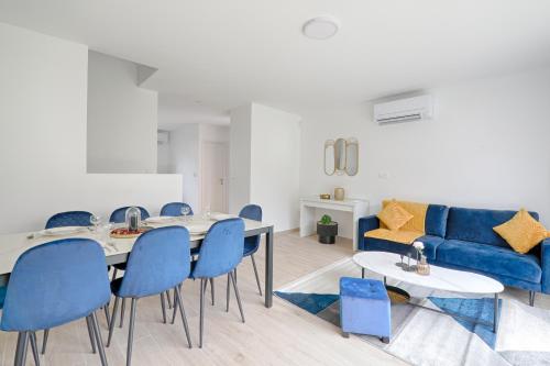 un salon avec une table et des chaises bleues dans l'établissement Maison Créteil - Maison climatisée avec jardin, à Créteil
