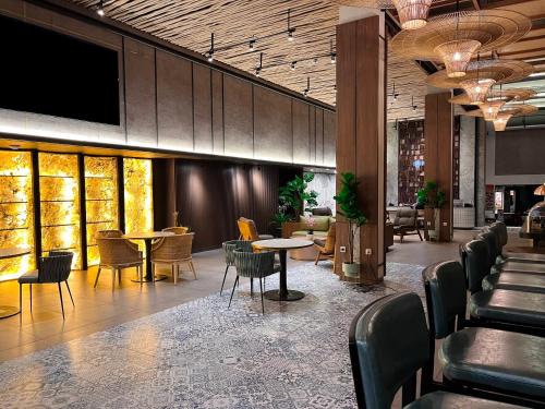 a restaurant with tables and chairs in a lobby at Luminor Hotel Legian Seminyak - Bali in Legian