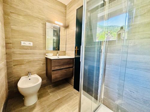 La salle de bains est pourvue de toilettes, d'un lavabo et d'une douche. dans l'établissement ComeCasa La Magdeleine 2 Bedrooms Chalet, à La Magdeleine