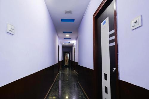 a hallway in a building with white walls and a long corridor at OYO Raghava Guest House in Hyderabad