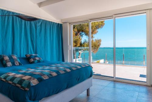 une chambre avec un lit et une vue sur l'océan dans l'établissement Villa Agua - Villa piscine privée, vue sur le lagon, à Mèze