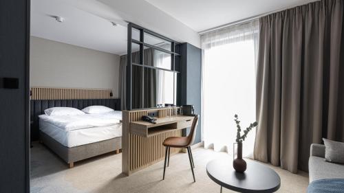a bedroom with a bed and a desk with a chair at Umi Hotel in Sopot
