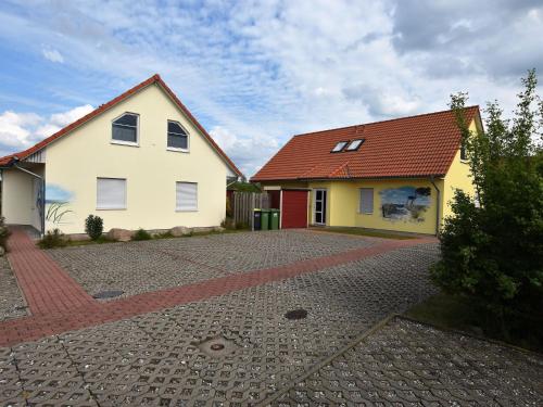 a white house with a red roof on a driveway at Modern Holiday Home in Boiensdorf near Sea in Boiensdorf