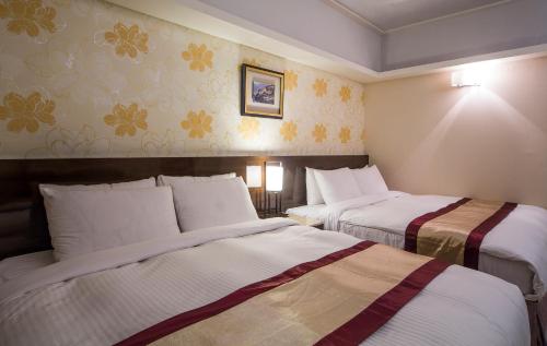 a hotel room with two beds in it at MILORD BOUTIQUE HOTEL in Kaohsiung