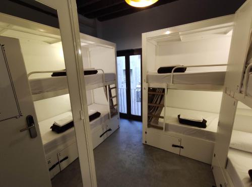 Black Swan Hostel Granada في غرناطة: غرفة مع ثلاثة أسرة بطابقين في غرفة