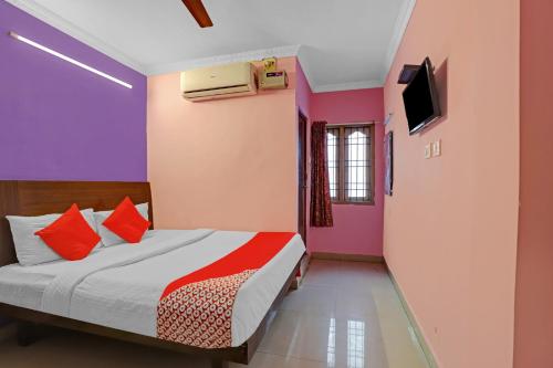 um quarto com uma cama e uma televisão na parede em OYO Flagship 82883 YUME Stays em Chennai