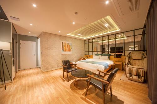 1 dormitorio con 1 cama, mesa y sillas en Naju Western Hotel en Naju
