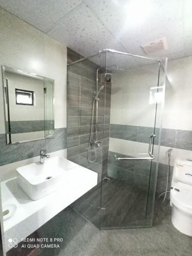 a bathroom with a sink and a shower and a toilet at Homestay MINH TÚ in Hue