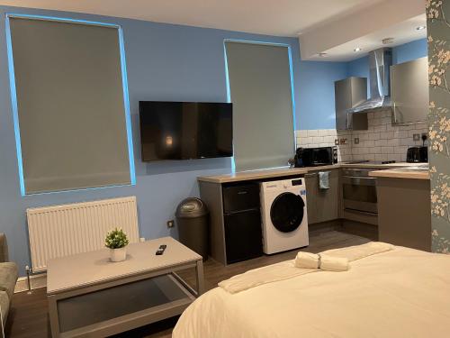 a small room with a bed and a kitchen at Luxurious Restful Studio Flat, Less Than 30 Mins From Centre! in London