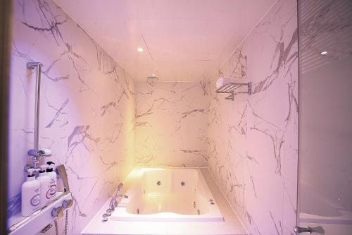 a bathroom with a shower and a toilet in it at Naju Western Hotel in Naju