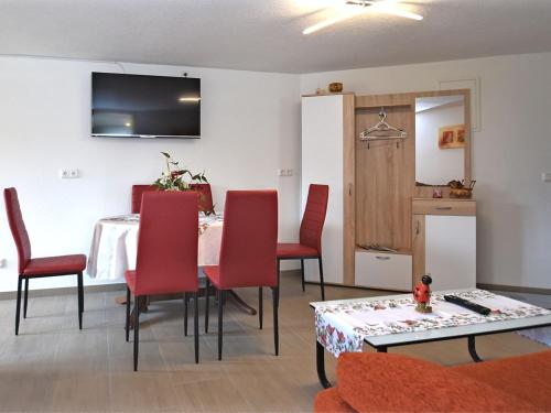 sala de estar con mesa y sillas rojas en Cozy Apartment in Lichtenhain Germany With Garden en Lichtenhain