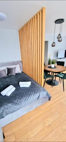 um quarto com uma cama com uma cabeceira em madeira e uma mesa em Studijos tipo būstas em Kretinga