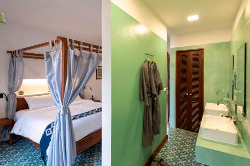 a bedroom with a bed and a bathroom with a sink at Residence Bassac in Champasak