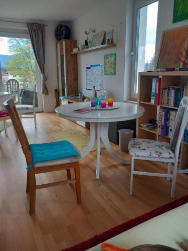 a living room with a white table and two chairs at Kunterbunt Seehaus in Faak am See