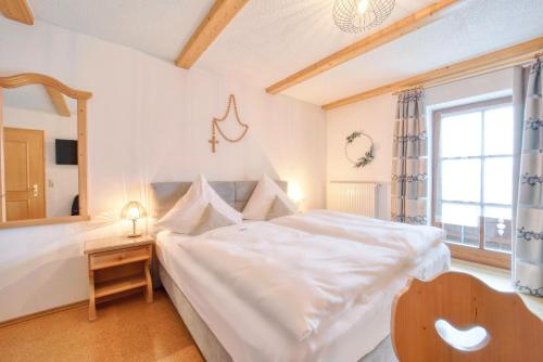 a bedroom with a large white bed and a window at Hotel Hirschenstein in Achslach