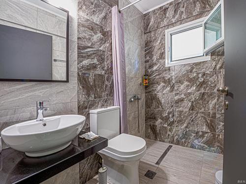 a bathroom with a sink and a toilet and a television at “Villa Chrysa” luxury house in Flámbouras