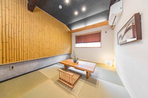 a room with a table and a yellow wall at JAPAVISTA Fuji in Osaka