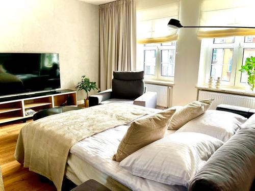 Un dormitorio con una cama grande y un televisor de pantalla plana. en Royal Attic Luxury Gdansk Old Town, en Gdansk