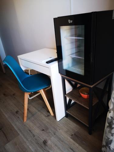 a desk with a tv and a blue chair at B&B Tonnarella Beach in Torre Forte