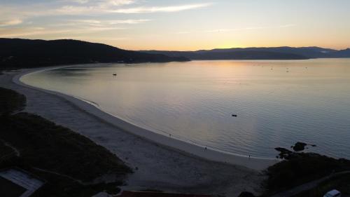 a view of a beach with the sun setting at La Casa de Ana en Fisterra in Fisterra