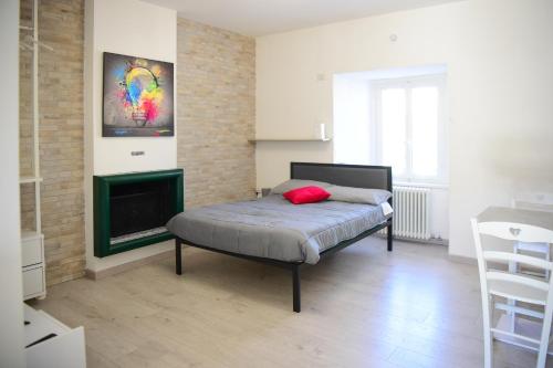 1 dormitorio con 1 cama y chimenea en La Casa dei Laghi 2 Comabbio Monate Maggiore Orta, en Mercallo