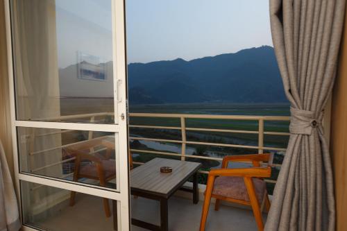 a balcony with a table and a chair and a window at Samiyog Tourist Resort in Pokhara