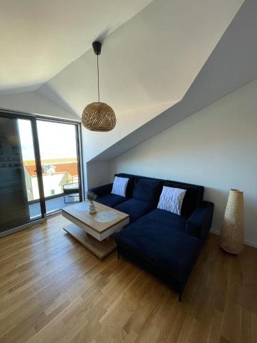 a living room with a blue couch and a table at Apartment Pearl of Postira in Postira