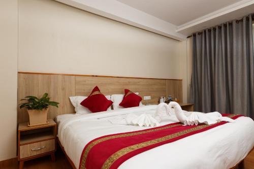 a bedroom with a large bed with towels on it at Samiyog Tourist Resort in Pokhara