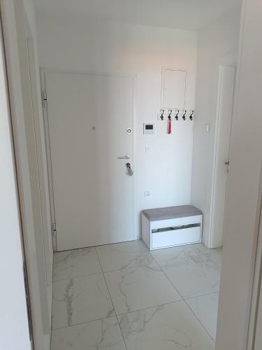 a white room with a bench on a tiled floor at Apartment Pearl of Postira in Postira