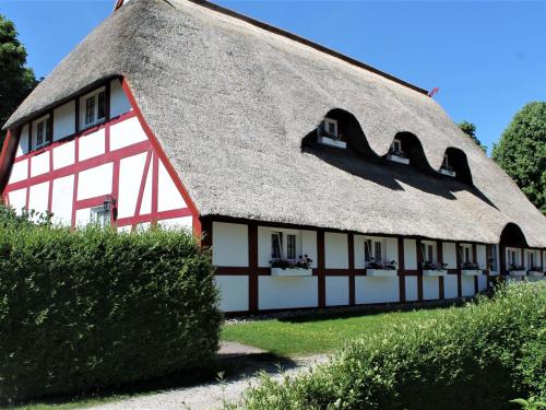 a red and white building with a thatched roof at Spacious Apartment in Wohlenberg Germany with Beach Near in Wohlenberg