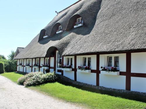 a thatch roofed building with flower boxes on it at Spacious Apartment in Wohlenberg Germany with Beach Near in Wohlenberg