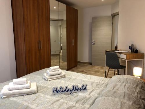 1 dormitorio con 1 cama con toallas en Laura's House by Holiday World, en Aosta
