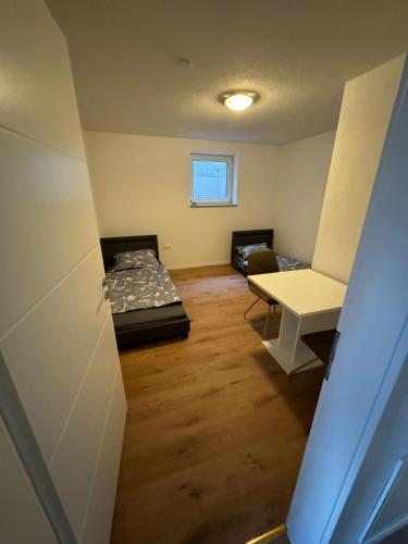 a small room with two beds and a table at Neues Apartment Ehingen in Ehingen