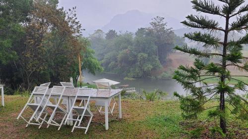 a table and chairs in front of a lake at Quality Time Farmstay: YardHouse#5 in Ban Pa Lau