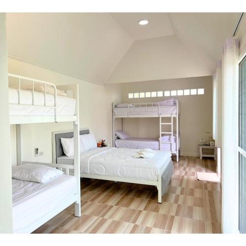 two bunk beds in a room with wooden floors at Quality Time Farmstay: YardHouse#5 in Ban Pa Lau