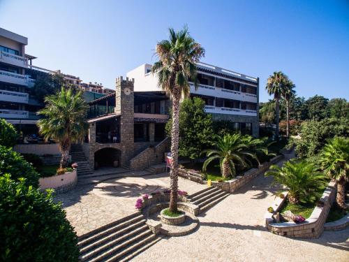 a building with a palm tree in a courtyard at Radisson Resort Ruza Vjetrova in Dobra Voda