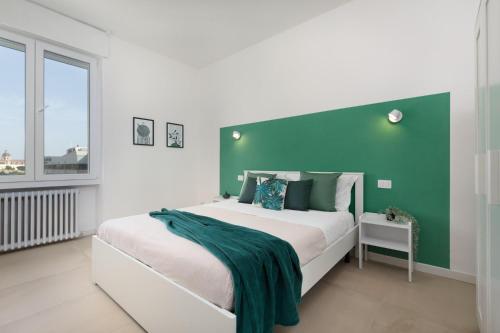 a bedroom with a large bed with a green headboard at Sve Suites Cagliari in Cagliari