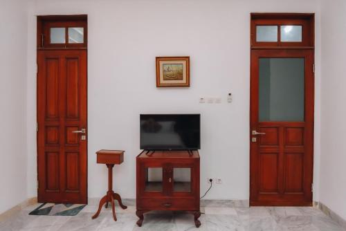 a room with two doors and a television on a table at Padma Amita Yogyakarta in Jetis